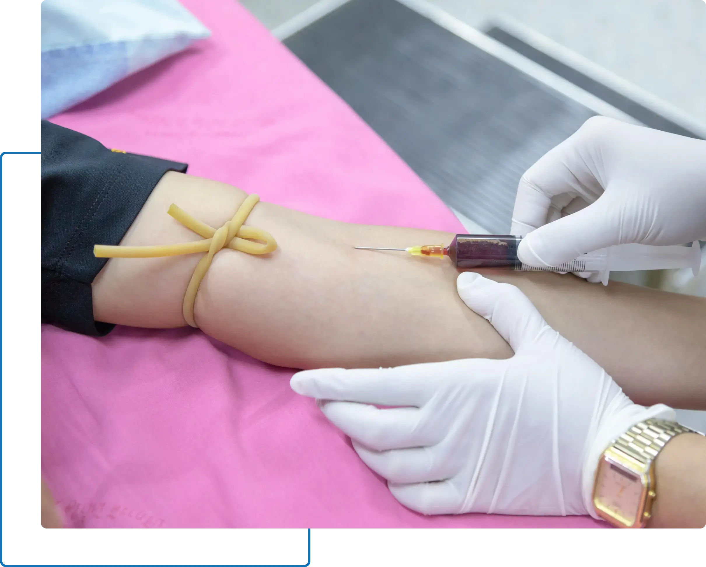 Medical professional in gloves drawing blood from a person's arm using a syringe.